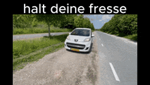 a white peugeot car is parked on the side of the road