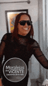 a woman wearing sunglasses stands in front of a sign that says moralejas de vicente leciones de la vida