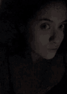 a close up of a woman 's face in the dark