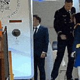 a man in a suit is standing in front of a machine that says public