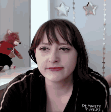 a woman is wearing a black jacket that says " dynamite twins "