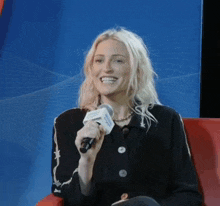 a woman is smiling while holding a microphone that says ' pacific northwest ' on it