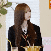 a girl in a school uniform is sitting in front of a pot