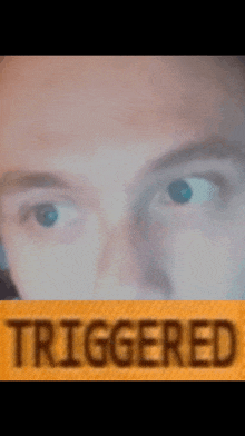 a close up of a man 's face with the word triggered on the bottom right