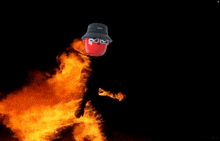 a person wearing a red mask and a black bucket hat is surrounded by fire
