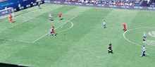a soccer game is being played on a field that has real written on the sidelines
