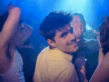 a man in a yellow shirt is smiling while dancing