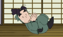 a cartoon character is laying on the floor in front of a window .