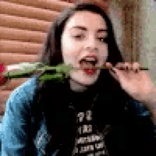 a woman is eating a rose with her tongue out .