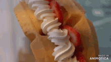 a close up of whipped cream and strawberries on a crepe