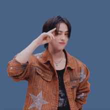 a young man wearing a brown striped jacket with a star on it