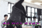 a group of people standing in a room with korean writing on the bottom