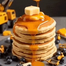 a stack of pancakes with syrup being poured on top .