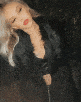 a woman with blonde hair wearing a black fur coat and red lipstick