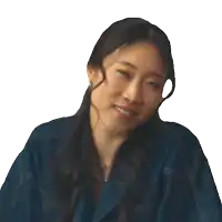a woman with long hair wearing a blue jacket smiles