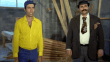 a man in a yellow shirt is standing next to another man