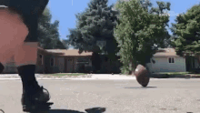 a person is balancing a basketball on their foot on the street .