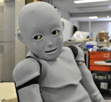 a robot with a bald head is standing in a room
