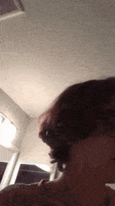 a woman is taking a selfie in a bathroom while wearing glasses and short hair .