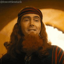 a man with long red hair and a beard is smiling with the hashtag @itsscottiesstark on the bottom