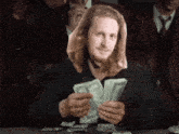 a man in a suit is holding a bunch of money