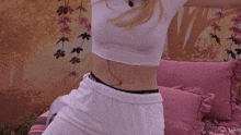 a woman in a white t-shirt sits on a pink couch