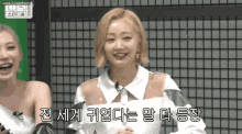 a woman with blonde hair is smiling and laughing in front of a green screen while another woman looks on .