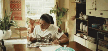 a woman is reading a magazine while sitting at a table .
