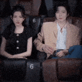 a man and a woman are sitting next to each other in a theater .