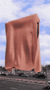 a large piece of cloth is hanging over a busy highway