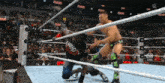 two men are wrestling in a ring and one of them is wearing a who shirt