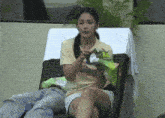 a woman sitting in a chair holding a bag that says ' rice ' on it