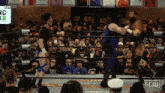 two wrestlers in a ring with a sign that says ' spring break ' on it