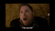 a man with his mouth open and the words " i 'm alive " above him