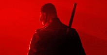 a man in a red suit holds a knife over his shoulder