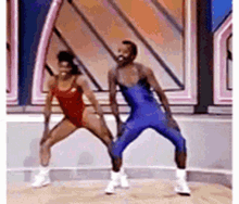a man and a woman are dancing together on a stage in a gym .