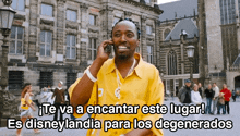 a man in a yellow shirt is talking on a cell phone with a caption in spanish