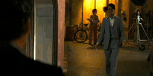 a man in a suit walking down a hallway