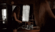 a woman standing in front of a table with a mirror