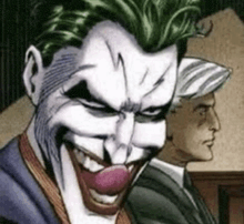 a close up of the joker 's face with a clown nose and a man in a suit behind him .