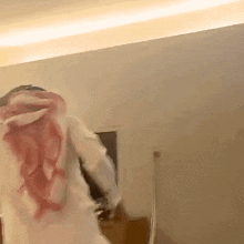 a man in a white shirt with a red scarf around his neck is standing in a room .