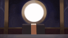 a person is sitting at a table with a box in front of them with a white light coming out of it .