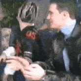 a man in a suit and tie is talking to another man in a black shirt with the number 08 on the back