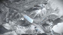 a black and white photo of a mountain with a blue stripe in the middle