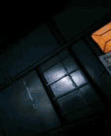 a blurry picture of a building with a yellow light shining through the window