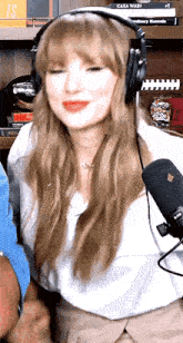 a woman wearing headphones and a microphone is smiling .