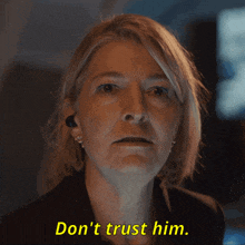 a woman says " don 't trust him " in a dark room
