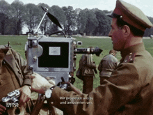 a man in a military uniform is pointing at a camera with the words wir prosteten uns zu and amüsierten uns below him