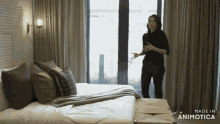 a woman stands in front of a bed with the words made in animotica on the bottom right