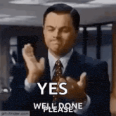 a man in a suit and tie is clapping his hands with the words yes well done please .